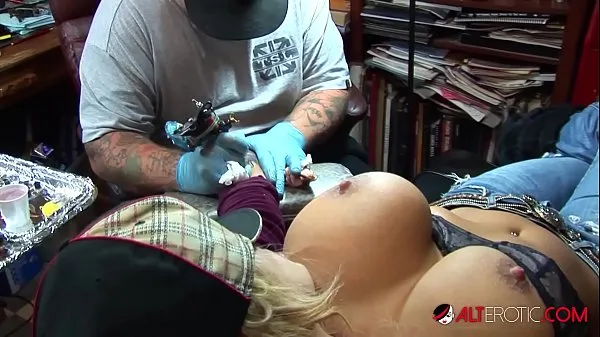 Sehen Sie sich Die vollbusige blonde Pornostarin zieht ihre riesigen Titten heraus, während sie sich ein Tattoo auf ihr Handgelenk tätowieren lässtEnergiefilme an